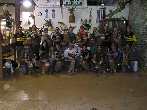 Image of group with taxidermized whitetail bucks 